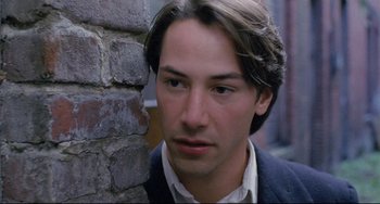 Movie still from “My Own Private Idaho” (1991), directed by Gus Van Sant – A man in a suit leaning against a brick wall; Close Up shot, Over the shoulder angle