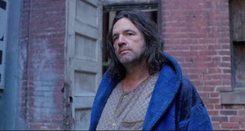 Movie still from “My Own Private Idaho” (1991), directed by Gus Van Sant – A man with long black hair wearing a blue robe; Medium shot, Low angle