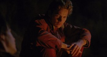 Movie still from “My Own Private Idaho” (1991), directed by Gus Van Sant – A man sitting on the ground in the dark; Medium shot, High angle