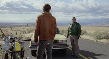 Movie still from “My Own Private Idaho” (1991), directed by Gus Van Sant – Two men standing on the side of a road near a car; Wide shot, Low angle