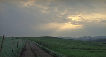 Movie still from “My Own Private Idaho” (1991), directed by Gus Van Sant – A dirt road on the side of the road near a grassy field; Extreme Wide shot, Low angle