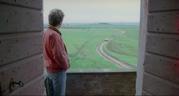 Movie still from “My Own Private Idaho” (1991), directed by Gus Van Sant – A person standing on a balcony looking out at an open field; Wide shot, High angle