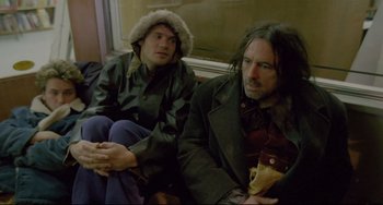 Movie still from “My Own Private Idaho” (1991), directed by Gus Van Sant – Two people sitting on a bench next to each other; Medium shot, Low angle