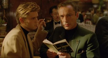 Movie still from “My Own Private Idaho” (1991), directed by Gus Van Sant – A man reading a book to another man in a suit; Close Up shot, Over the shoulder angle