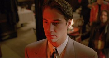 Movie still from “My Own Private Idaho” (1991), directed by Gus Van Sant – A man wearing a suit and tie in a room; Close Up shot, Low angle