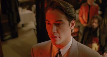 Movie still from “My Own Private Idaho” (1991), directed by Gus Van Sant – A man in a suit and tie looking to his left; Close Up shot, Over the shoulder angle