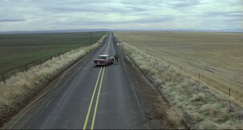 Movie still from “My Own Private Idaho” (1991), directed by Gus Van Sant – Two people standing on the side of the road next to a car; Extreme Wide shot, High angle