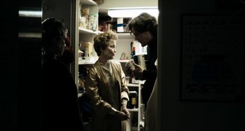 Movie still from “My Son, My Son, What Have Ye Done” (2009), directed by Werner Herzog – A woman standing next to a man in a kitchen; Medium shot, Over the shoulder angle