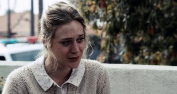 Movie still from “My Son, My Son, What Have Ye Done” (2009), directed by Werner Herzog – A young woman with blonde hair wearing a white polka dot shirt; Close Up shot, Over the shoulder angle