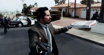 Movie still from “My Son, My Son, What Have Ye Done” (2009), directed by Werner Herzog – A man in a suit and tie holding a gun; Medium shot, High angle