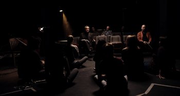 Movie still from “My Son, My Son, What Have Ye Done” (2009), directed by Werner Herzog – A group of people sitting in a theater; Wide shot, High angle