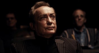 Movie still from “My Son, My Son, What Have Ye Done” (2009), directed by Werner Herzog – An older man wearing a suit and tie looking to his left; Close Up shot, Low angle