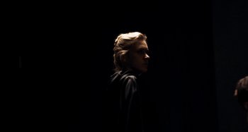 Movie still from “My Son, My Son, What Have Ye Done” (2009), directed by Werner Herzog – A woman in a black jacket standing in the dark; Medium shot, Low angle