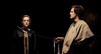 Movie still from “My Son, My Son, What Have Ye Done” (2009), directed by Werner Herzog – A man and a woman are holding onto a piece of cloth; Medium shot, Over the shoulder angle