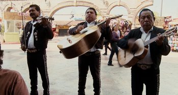 Movie still from “My Son, My Son, What Have Ye Done” (2009), directed by Werner Herzog – A group of men playing instruments in a crowd; Wide shot, High angle