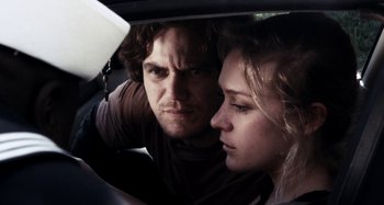 Movie still from “My Son, My Son, What Have Ye Done” (2009), directed by Werner Herzog – A man and a woman in the back seat of a car; Close Up shot, Low angle