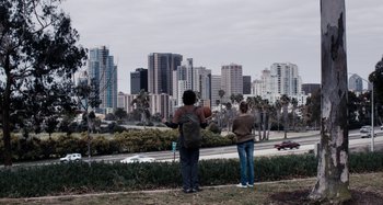 Movie still from “My Son, My Son, What Have Ye Done” (2009), directed by Werner Herzog – Two people looking out at a city skyline; Wide shot, Over the shoulder angle