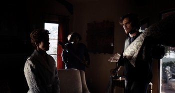 Movie still from “My Son, My Son, What Have Ye Done” (2009), directed by Werner Herzog – A group of people standing in a living room; Wide shot, Over the shoulder angle