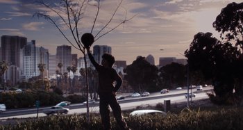 Movie still from “My Son, My Son, What Have Ye Done” (2009), directed by Werner Herzog – A man standing in the grass holding a basketball; Wide shot, Low angle