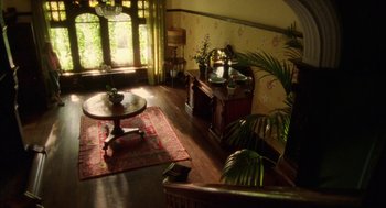 Movie still from “My Summer of Love” (2004), directed by Pawel Pawlikowski – A living room filled with furniture next to a large window; Wide shot, High angle