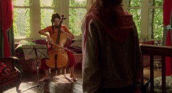 Movie still from “My Summer of Love” (2004), directed by Pawel Pawlikowski – A woman playing the cello in front of a group of people; Wide shot, Over the shoulder angle