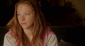 Movie still from “My Summer of Love” (2004), directed by Pawel Pawlikowski – A young woman sitting in a chair looking at the camera; Close Up shot, Over the shoulder angle