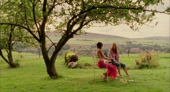 Movie still from “My Summer of Love” (2004), directed by Pawel Pawlikowski – Two women sitting in a field under a tree; Wide shot, Over the shoulder angle