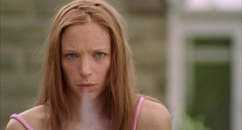Movie still from “My Summer of Love” (2004), directed by Pawel Pawlikowski – A woman with red hair is smoking a cigarette; Close Up shot, Low angle
