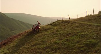 Movie still from “My Summer of Love” (2004), directed by Pawel Pawlikowski – A dirt bike sitting on top of a grassy hill; Extreme Wide shot, Low angle