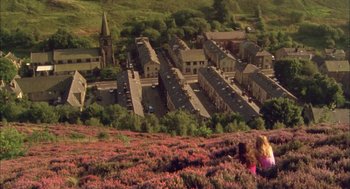 Movie still from “My Summer of Love” (2004), directed by Pawel Pawlikowski – Two people in a field of flowers looking down at a town; Extreme Wide shot, High angle