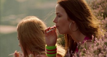Movie still from “My Summer of Love” (2004), directed by Pawel Pawlikowski – A woman is holding a cell phone up to her mouth; Close Up shot, Over the shoulder angle