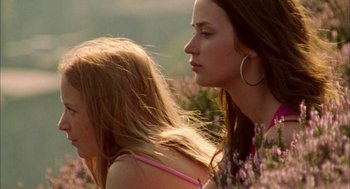 Movie still from “My Summer of Love” (2004), directed by Pawel Pawlikowski – A woman standing next to a young girl in a field of purple flowers; Close Up shot, Low angle