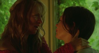 Movie still from “My Summer of Love” (2004), directed by Pawel Pawlikowski – Two women in a room with trees in the background; Close Up shot, Over the shoulder angle