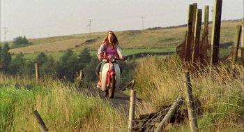 Movie still from “My Summer of Love” (2004), directed by Pawel Pawlikowski – A woman riding a scooter down a dirt road; Wide shot, Low angle