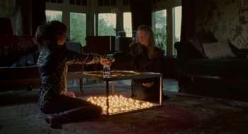 Movie still from “My Summer of Love” (2004), directed by Pawel Pawlikowski – Two people sitting at a table in a living room; Wide shot, High angle