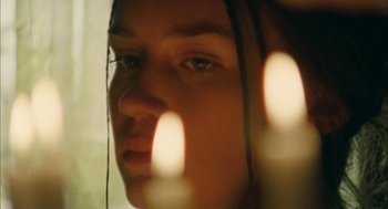 Movie still from “My Summer of Love” (2004), directed by Pawel Pawlikowski – A woman's face with candles in the background; Close Up shot, Low angle