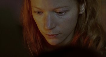 Movie still from “My Summer of Love” (2004), directed by Pawel Pawlikowski – A woman's face in a dimly - lit room; Close Up shot, Low angle