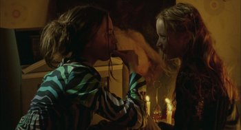Movie still from “My Summer of Love” (2004), directed by Pawel Pawlikowski – Two young girls are standing in front of candles; Close Up shot, Over the shoulder angle