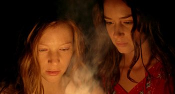 Movie still from “My Summer of Love” (2004), directed by Pawel Pawlikowski – Two young women are looking at a candle in the dark; Close Up shot, Low angle