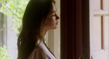 Movie still from “My Summer of Love” (2004), directed by Pawel Pawlikowski – A woman standing in front of a window with her head turned to the side; Medium shot, Low angle