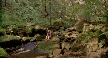 Movie still from “My Summer of Love” (2004), directed by Pawel Pawlikowski – A woman sitting on a rock in the middle of a forest; Extreme Wide shot, High angle
