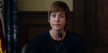 Movie still from “13 Reasons Why” (2017), created by Brian Yorkey – A woman sitting in front of a microphone in a room; Close Up shot, Over the shoulder angle