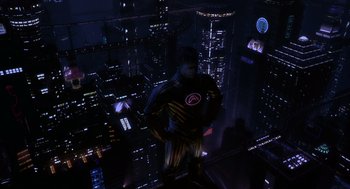 Movie still from “Mystery Men” (1999), directed by Kinka Usher – A man standing on a ledge in the middle of a city at night; Extreme Wide shot, High angle