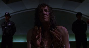 Movie still from “Mystery Men” (1999), directed by Kinka Usher – A man with long curly hair holding two bananas; Close Up shot, Low angle