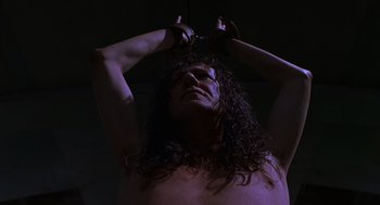 Movie still from “Mystery Men” (1999), directed by Kinka Usher – A man with long hair is holding a pair of scissors; Close Up shot, Low angle