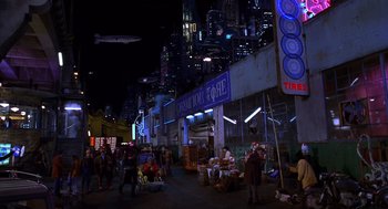 Movie still from “Mystery Men” (1999), directed by Kinka Usher – People are standing in the middle of a city street at night; Extreme Wide shot, High angle