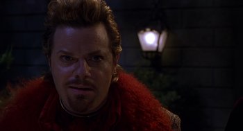 Movie still from “Mystery Men” (1999), directed by Kinka Usher – A person wearing a red jacket; Close Up shot, Over the shoulder angle