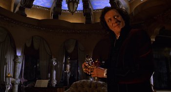 Movie still from “Mystery Men” (1999), directed by Kinka Usher – A man holding a cup in his hands; Medium shot, Low angle