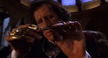 Movie still from “Mystery Men” (1999), directed by Kinka Usher – A man holding a pair of writing implements in his hands; Close Up shot, Low angle