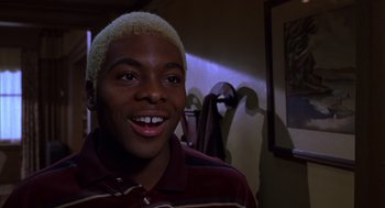 Movie still from “Mystery Men” (1999), directed by Kinka Usher – A young man with blonde hair smiling for the camera; Close Up shot, Low angle